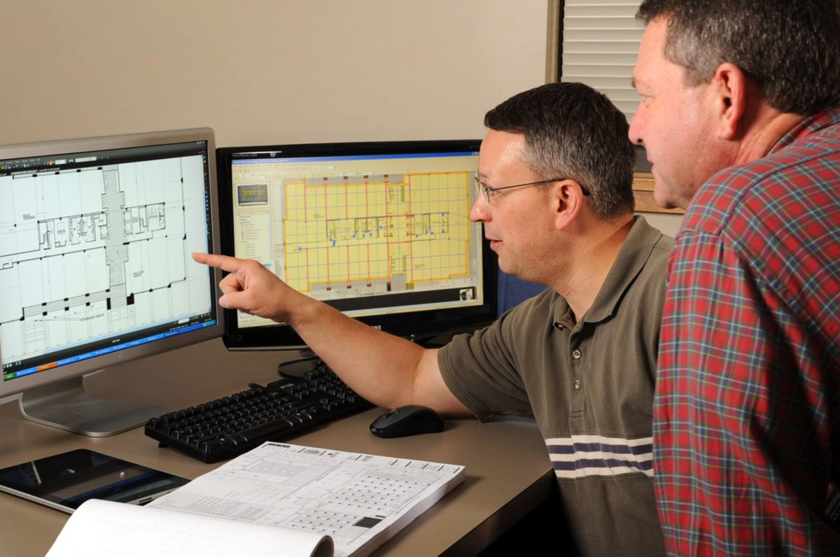 two male workers looking over plans and discussing Pre-construction questions