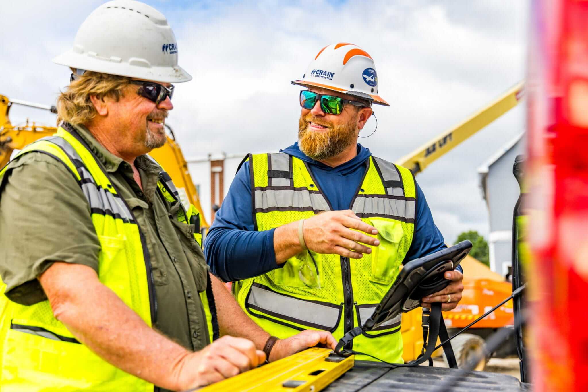 two crain construction employees talking about project